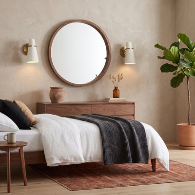 Reeva 1-light Wall Sconce in Modern Brass and Glossy Ecru shade, AI-visualized bedroom scene - Golden Lighting