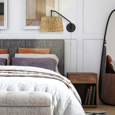 Ryleigh 1-light Swing Arm Wall Lamp in Matte Black and Woven Sweet Grass shade, shown in a room setting - Golden Lighting