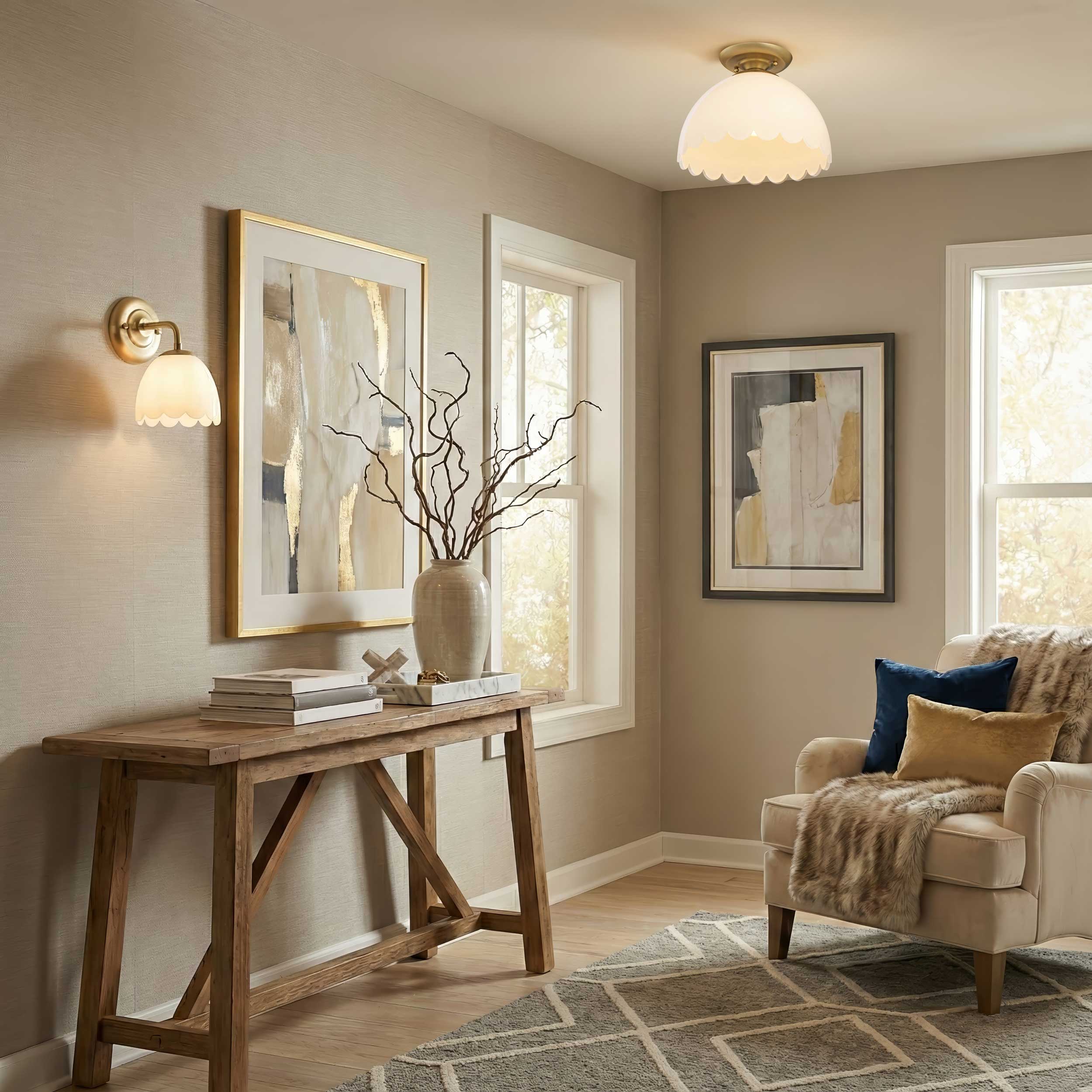 Living room with wooden table, armchair, and wall art illuminated by Dorinda Semi-Flush mount and 1-Light wall sconce in brushed champagne brass.